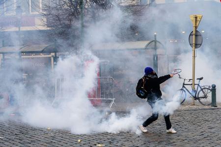 Ein Demonstrant schlägt bei den Protesten in Brüssel gegen einen Tränengasbehälter. 