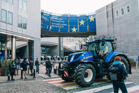 Demonstranten und Bereitschaftspolizei stehen vor dem Eingang des Europäischen Parlaments.