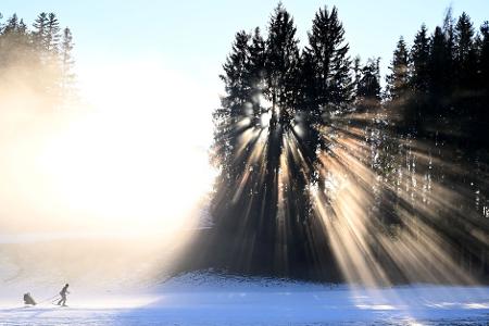 Eine Person ist mit Langlaufski am Hochplateau Ramsau am Dachstein unterwegs.