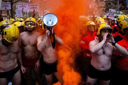 Spanische Feuerwehrleute demonstrieren in Badehosen in Barcelona. 