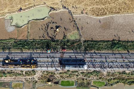 Ein Bagger hebt eine Grube aus, um den Kadaver eines Elefanten zu begraben, der bei der Kollision mit einem Zug ums Leben kam.