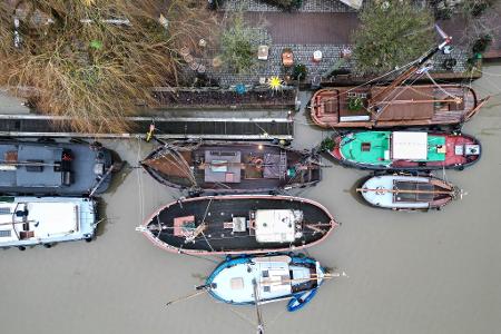 Traditionsschiffe liegen im grauen Wasser im Hafen von Leer.