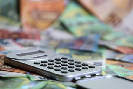 Ein Taschenrechner liegt auf verschiedenen Euro-Banknoten. (Symbolbild)