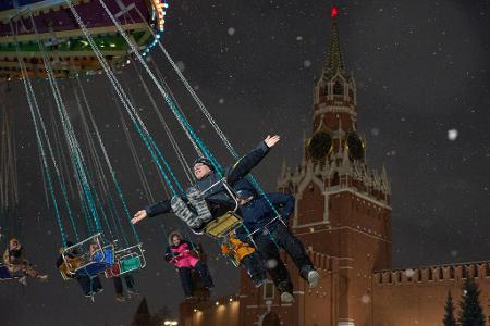 Karussell vor Kremlkulisse: Kinder vergnügen sich auf dem Weihnachtsmarkt am Roten Platz