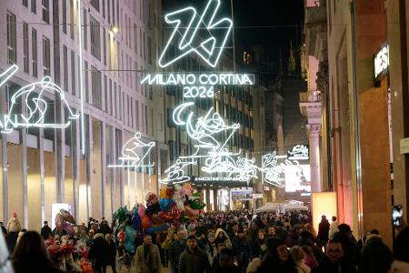 Menschen spazieren durch das Stadtzentrum Mailands, welches mit Beleuchtung für die bevorstehenden Olympischen Winterspiele in Italien 2026 geschmückt ist.