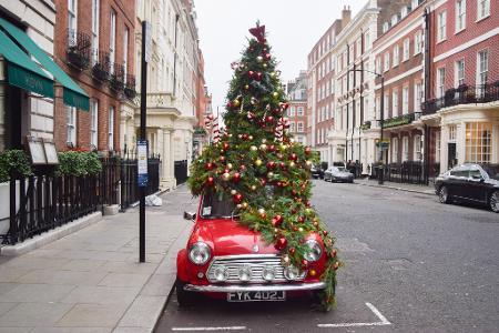 Ein mit einem Weihnachtsbaum geschmückter Mini steht in London auf der Straße.