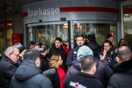 Polizeibeamte sprechen mit möglicherweise betroffenen Kunden der Sparkassenfiliale in Buer.