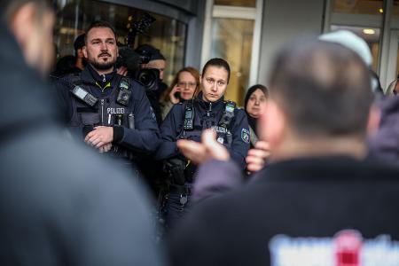 Polizeibeamte sprechen mit möglicherweise betroffenen Kunden der Sparkassenfiliale in Buer.