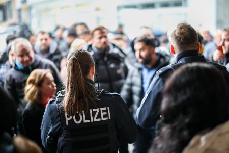 Nach der Räumung des Vorraums der Sparkassenfiliale sichern Polizeibeamte den Bereich vor der Sparkasse.