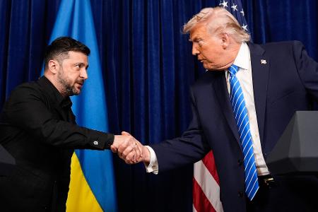 US-Präsident Donald Trump (r) und Wolodymyr Selenskyj, Präsident der Ukraine, geben sich die Hand.