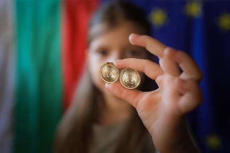 Ein Mädchen zeigt neue Euro-Münzen mit bulgarischen Symbolen.