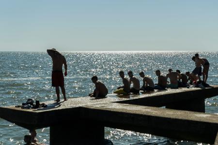 Menschen sitzen auf einem Dock in Montevideo.