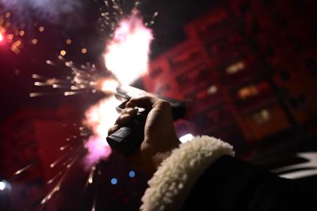 Ein Mann schießt während der Silvesternacht in Berlin mit einer Schreckschusspistole.