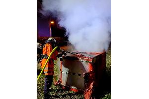 Einsatzkraft beim Ablöschen eines Containers