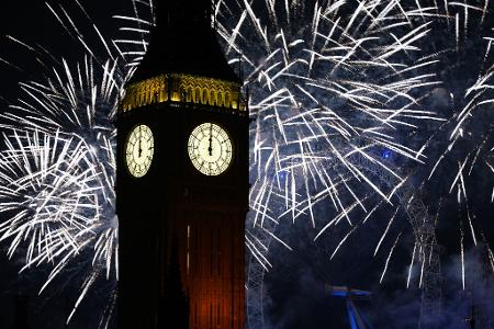 Feuerwerk erhellt den Himmel über dem Elizabeth Tower und dem London Eye im Zentrum Londons während der Neujahrsfeierlichkeiten.