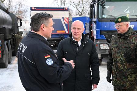 Oliver Schultz (l-r) vom Technischen Hilfswerk, Kai Wegner (CDU), Regierender Bürgermeister, und Brigadegeneral Horst Busch, unterhalten sich.