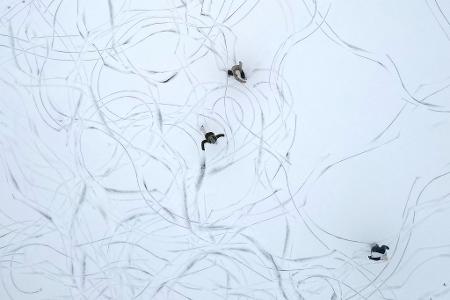 Muster im Schnee: Eine Luftaufnahme zeigt Schlittschuhläufer auf einem zugefrorenen See in Österreich.