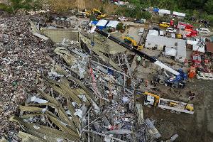 Die Einsatzkräfte suchen unter anderem mit einem Kran in den Abfall-Massen.