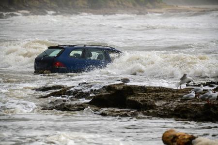 Wellen prallen gegen ein Fahrzeug, das nach einer Sturzflut in der Nähe des Wye River.