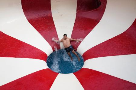Ein Mann stürzt eine Wasserrutsche in einem öffentlichen Schwimmbad im Stadtteil Puente Piedra außerhalb von Lima hinunter.
