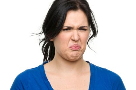 Frau verzieht voller Ekel das Gesicht