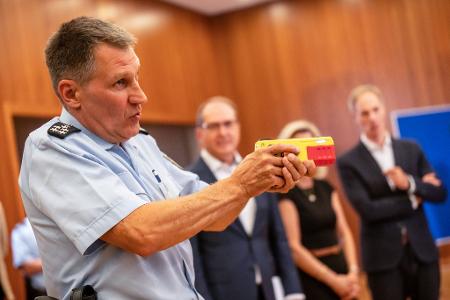 Ein Polizist erklärte die Funktionsweise eines Distanz-Elektroimpulsgeräts im vergangenen Jahr im Innnenministerium. (Archivfoto)