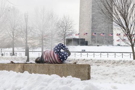 Ein Obdachloser ruht sich nach einem schweren Wintersturm in der Nähe des Washington Monuments auf.